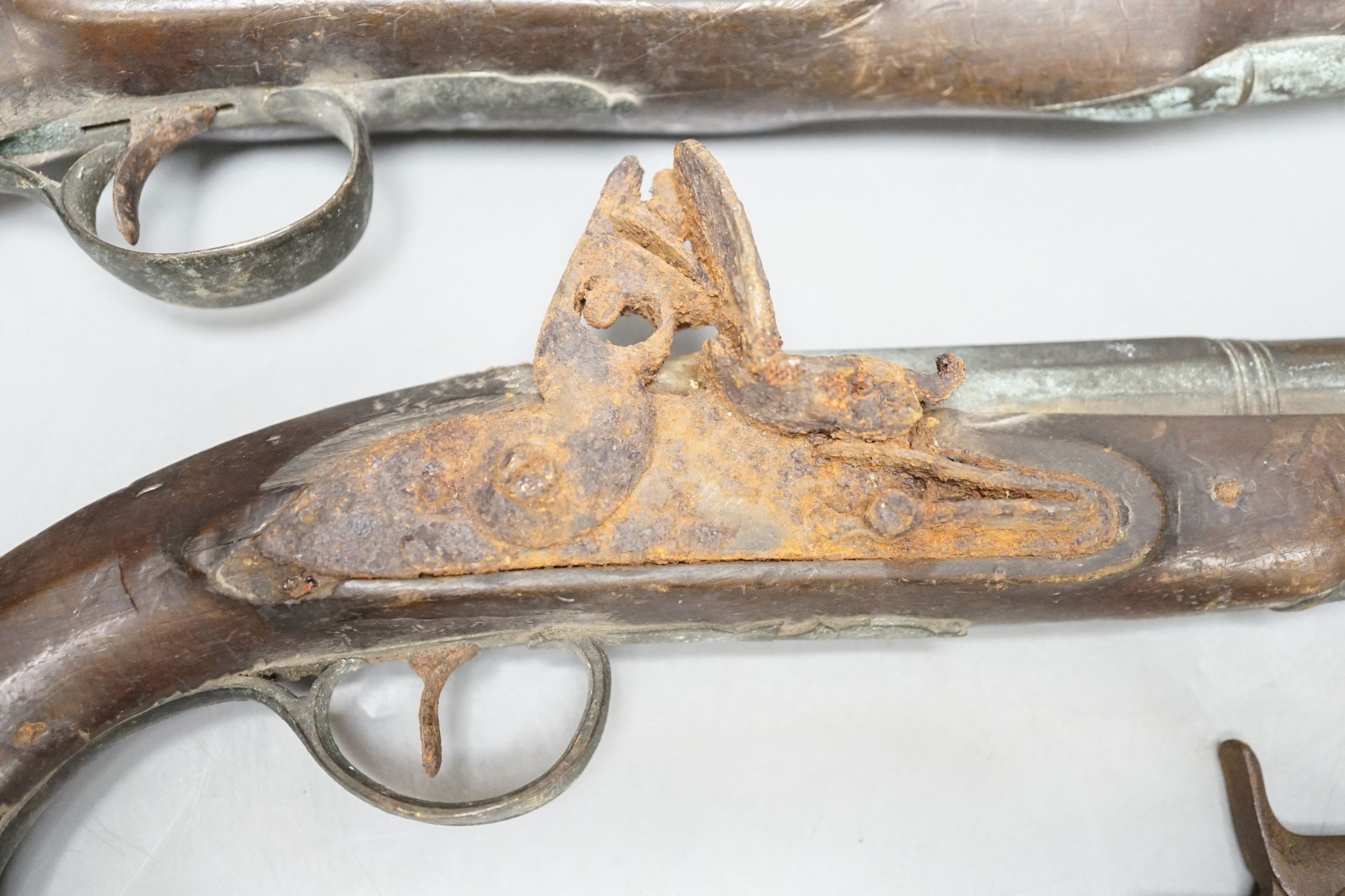 Two 19th century flintlock pistols and a pocket pistol, largest 40 cms long.
